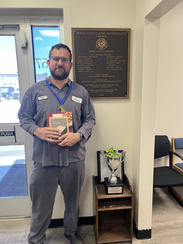 Photo of first place individual stepper, Matt, posing with his medal and other prizes